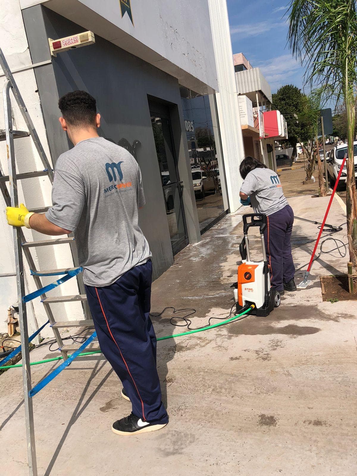 Equipe realizando lavagem e manutenção de fachada comercial