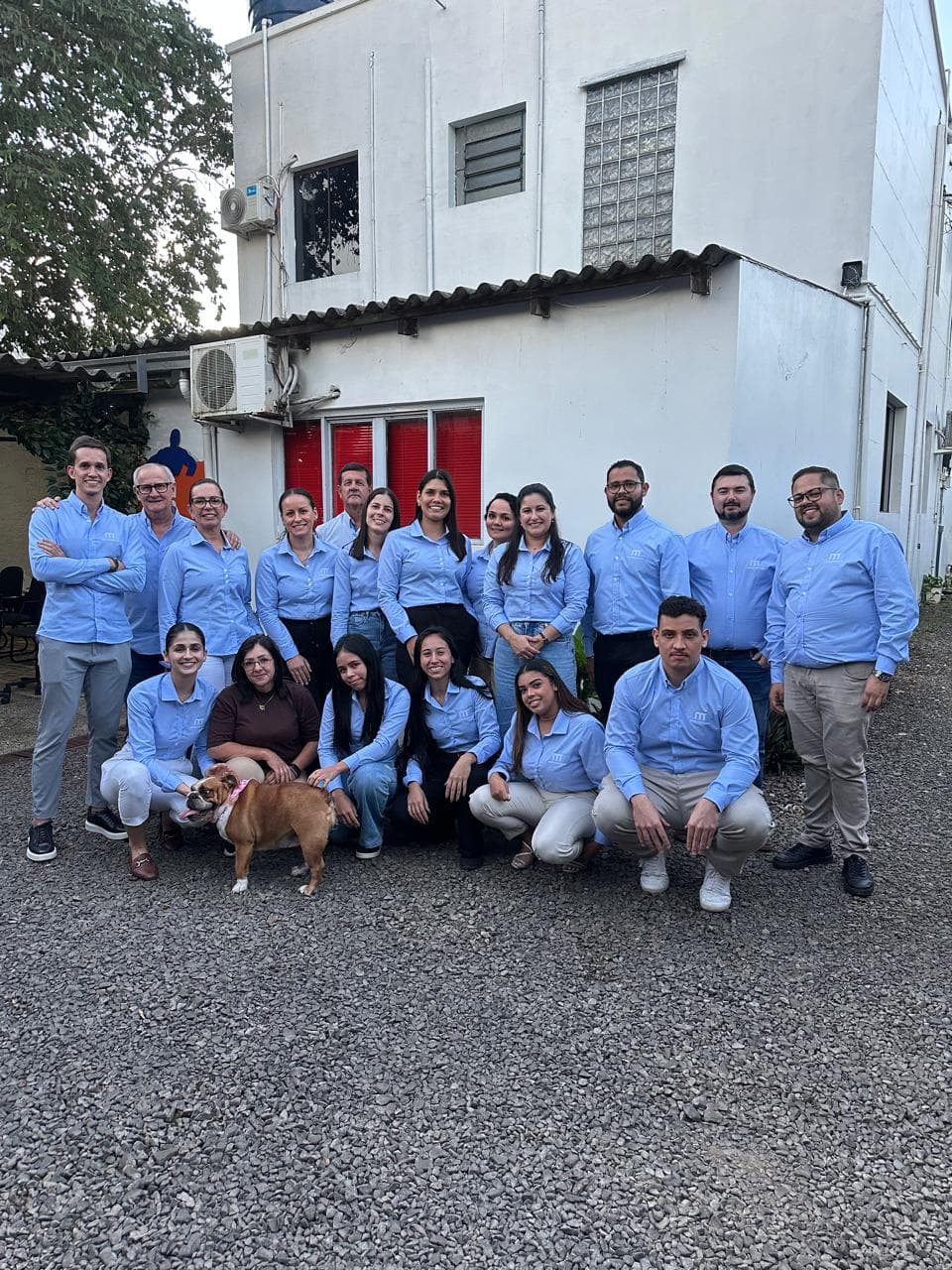 Equipe administrativa da Mercoservicers reunida em frente à sede da empresa